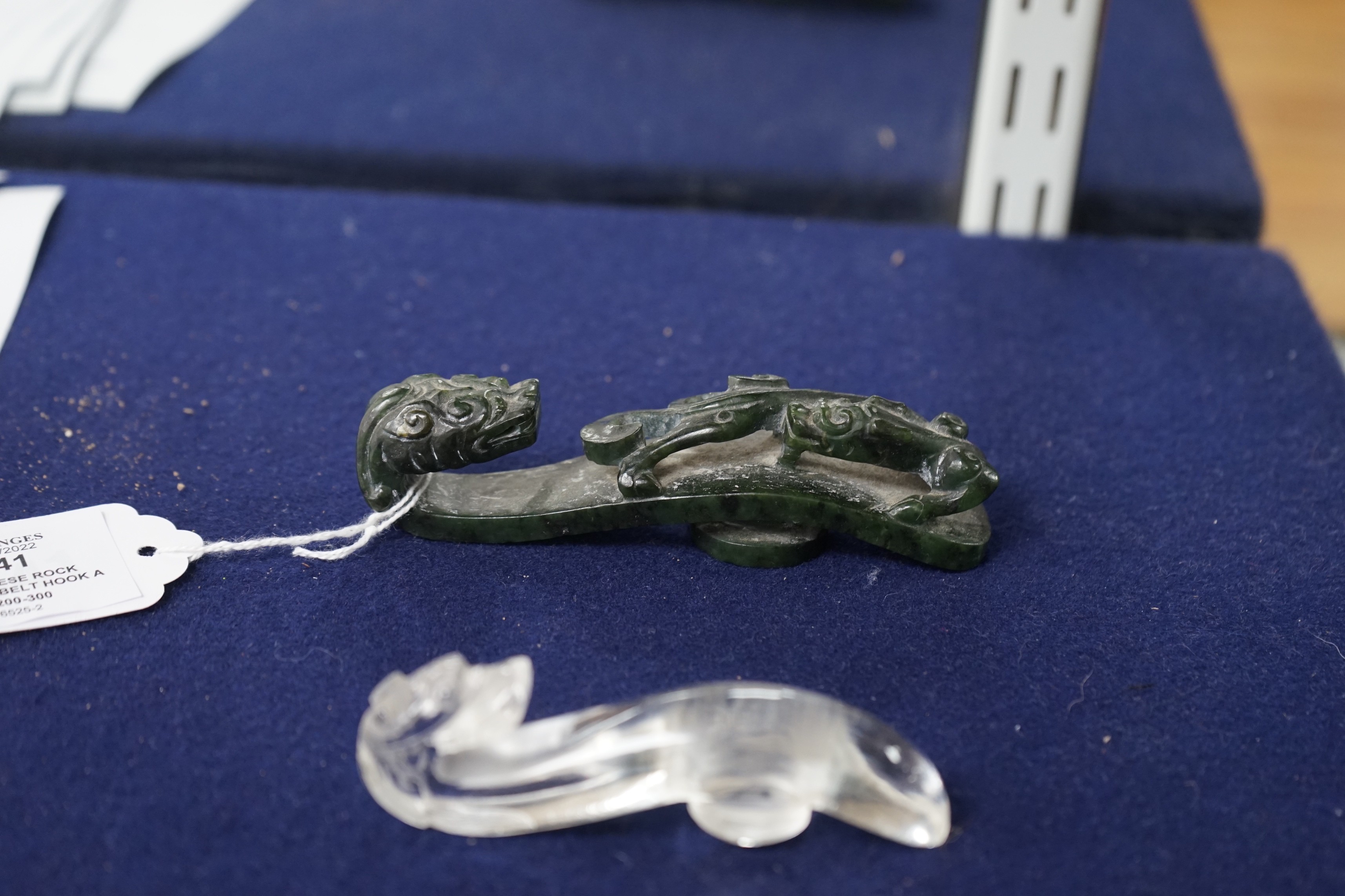 A Chinese rock crystal belt hook and a Chinese spinach green jade belt hook (2), largest 12cms long